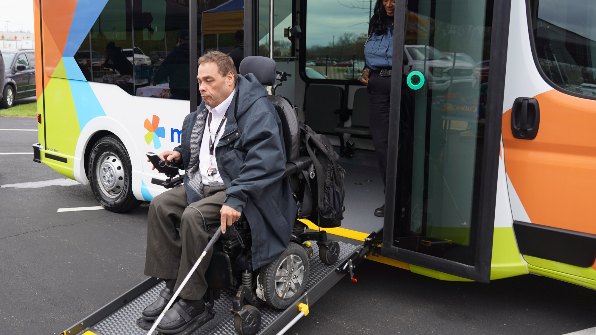 man in wheelchair using ramp to get off accessible bus