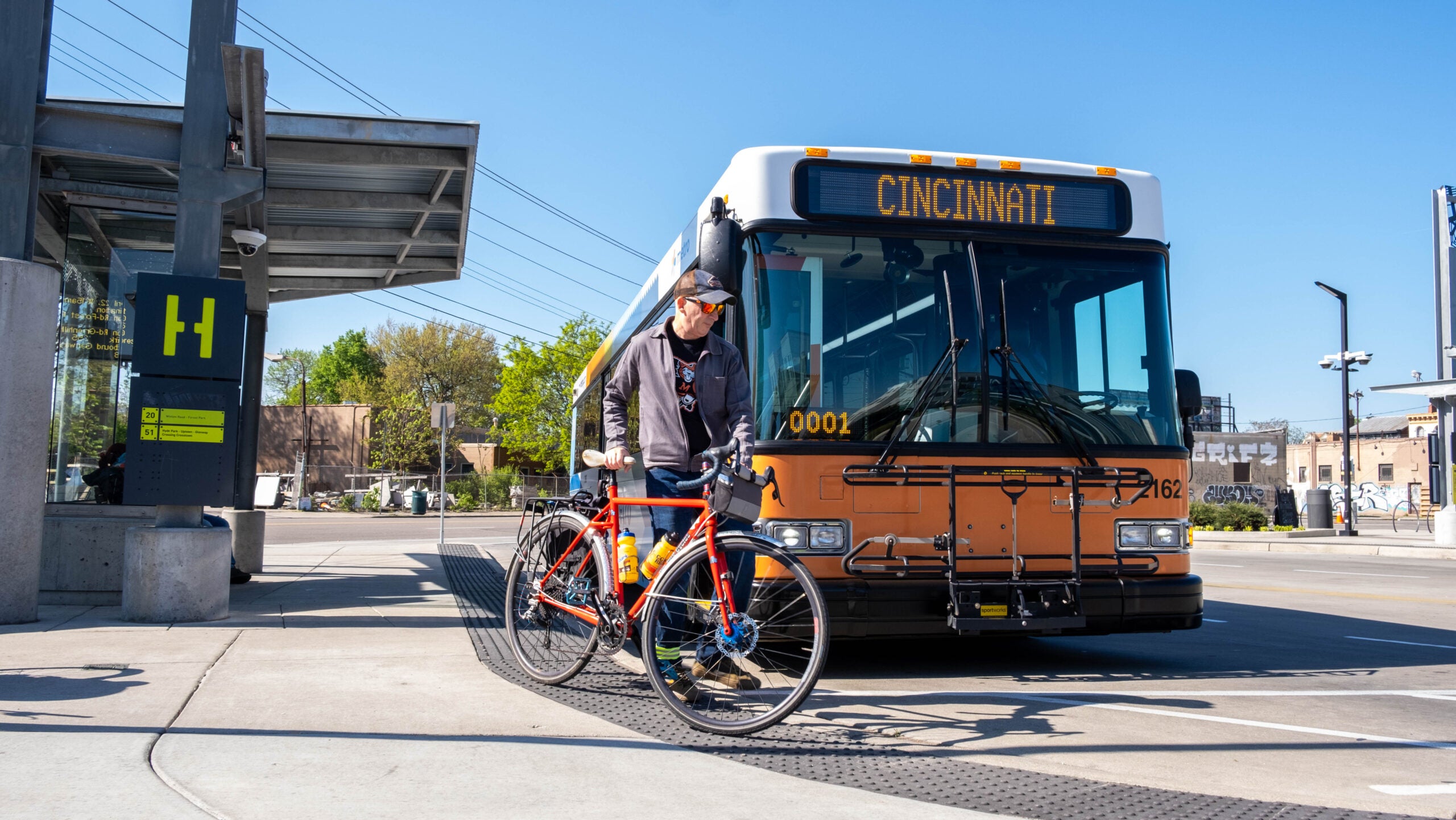 man takes bike to sidewalk away from bus